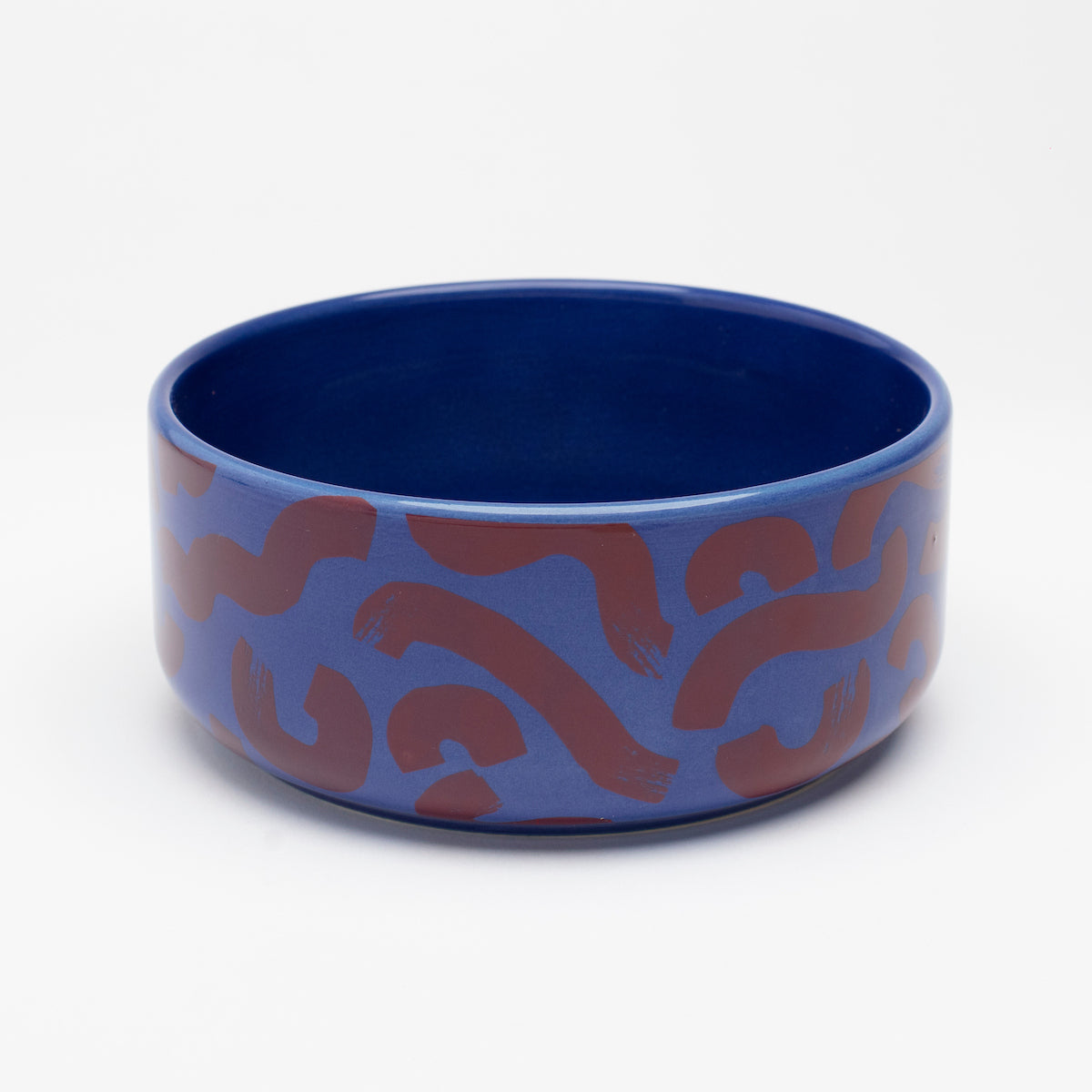 Front view of Flow ceramic dog bowl by Hot Doggies with red and blue pattern, made from durable ceramic, dishwasher safe, ideal for dog food and water.