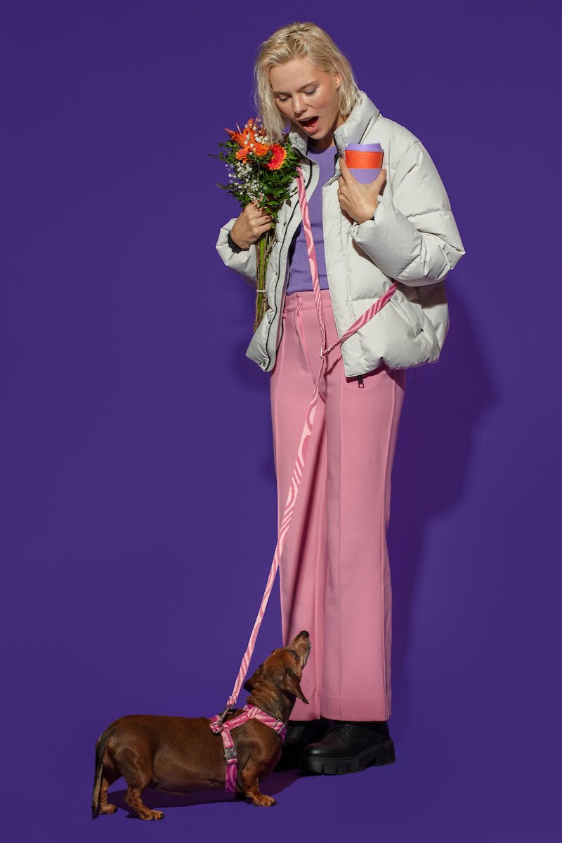 Woman happily looking at her dog while wearing Hot Doggies pink wave design hands-free leash.