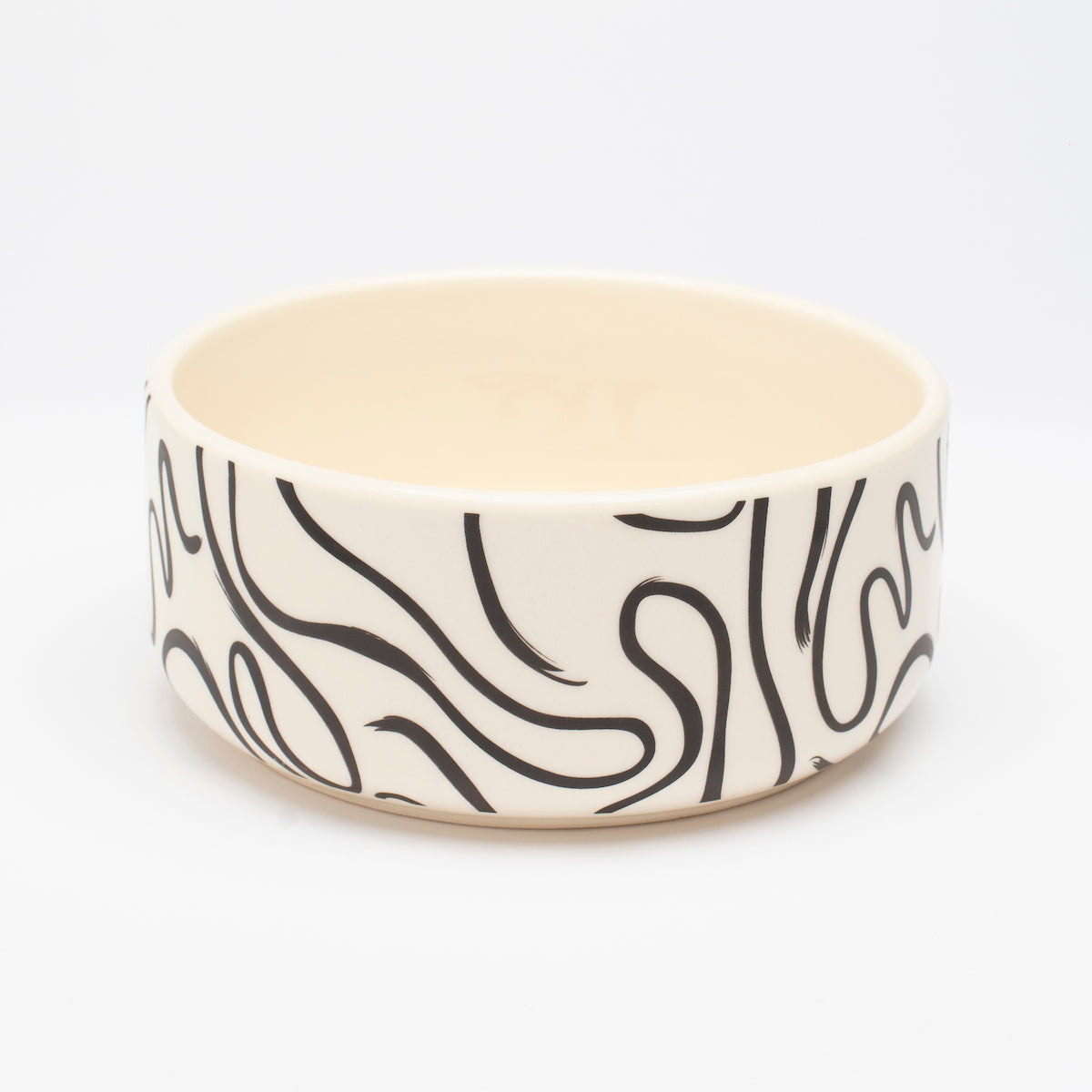 Modern black and white ceramic pet bowl with minimalist design, bold black line accents, and glossy white glaze—perfect for food or decorative use