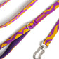 Purple and yellow patterned dog leash with a silver clasp on a white background.