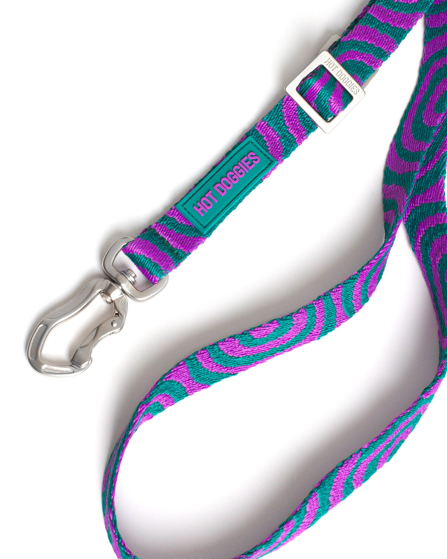 Dog leash with purple and teal pattern and silver clasp on a white background.