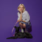 A blonde woman with a bob haircut, wearing a light purple t-shirt and blue skirt, squats next to a black dog lying down and holding Hot Doggies Classic Leash Lily Coral, featuring a chic coral and lilac fine-line pattern. Eco-friendly, comfortable leash with padded handle and premium hardware.