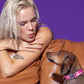 Dog wearing the Roxy Pink Collar on a sofa, accompanied by a model, featuring a vibrant pink wave design and durable buckle for a stylish and comfortable fit.
